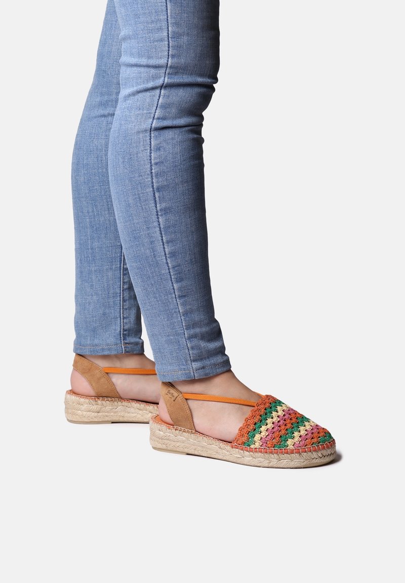 Sandales espadrilles avec tige tissée multicolore, accents en cuir marron et semelle en jute tressé. Brides ajustables pour un meilleur ajustement.