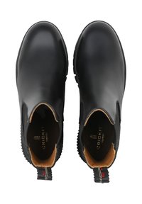 Stivaletti alla caviglia in pelle nera con pannelli laterali elastici, punta arrotondata e suola in gomma testurizzata. Caratterizzati da una fodera interna color cuoio a contrasto e un tirante posteriore.