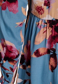 Ziedu kleita ar zilu fonu, lieliem bordo un persiku krāsas ziedu rakstiem, kroku svārkiem un pogu detaļām uz piedurknes.