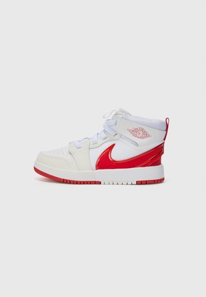 Biało-czerwony sneaker Nike Air Jordan typu high-top z czerwonym logo Swoosh i emblematem skrzydeł Air Jordan na kołnierzu wokół kostki, prezentowany na szarym tle.