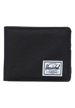 Cartera de tela negra con forma rectangular, etiqueta de marca blanca, superficie texturizada y acento rojo en el lateral. Diseño compacto y sencillo.