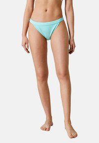 Mintgrön bikiniunderdel med texturerad yta, låg midja och bred, platt midjeband. Lämplig för simning och strandkläder.