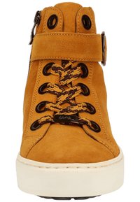 Botín de ante beige con cordones redondos en marrón y dorado, ojales metálicos, cremallera lateral y suela de goma blanca. Superficie texturizada y detalle de costura.