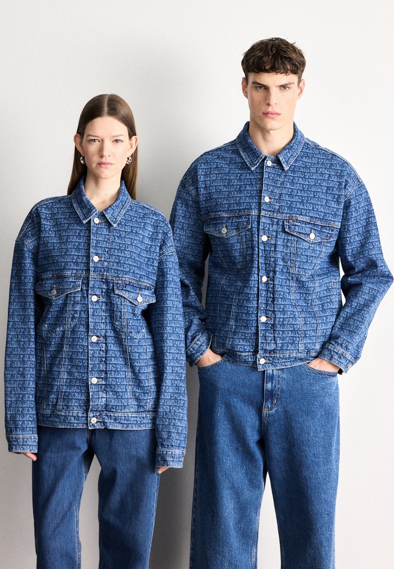 Traper jakne s uzorkovanom teksturom u nijansama plave, s prednjim gumbima i džepovima na prsima, nošene uz odgovarajuće traperice.