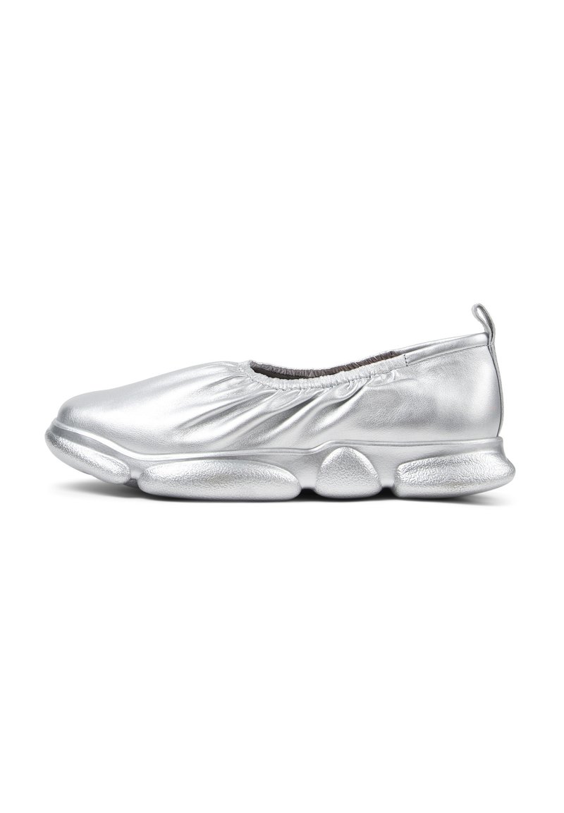 Silver slip-on shoe with a gathered, textured upper and a cushioned outsole featuring rounded, elongated pods. Lightweight design enhances flexibility.