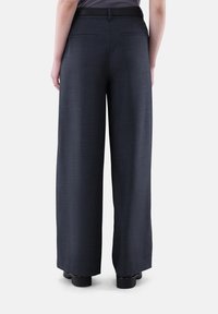 Weit geschnittene, dunkelgraue Hosen mit glatter Textur, ausgestattet mit einem Bund und zwei Gesäßtaschen. Der Stoff hat ein dezentes Muster.