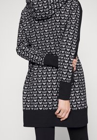 Zwarte capuchontrui met een herhalend wit EA7-logo patroon, voorzien van geribbelde manchetten en een ontspannen pasvorm voor comfort.