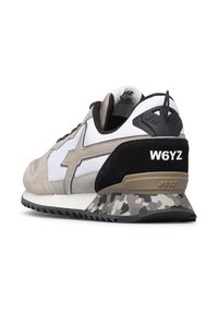 Sneaker con pannelli beige, bianchi e neri, logo W6YZ sul tallone e sulla suola, intersuola con motivo camouflage, vista angolata dal retro e lato destro.