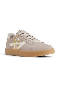 Sneaker in pelle beige con una striscia bianca di accento, punta rotonda, superficie testurizzata e suola in gomma naturale. Presenta charm decorativi sui lacci.
