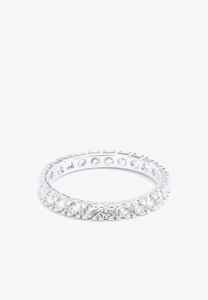 Bague jonc éternité en argent sertie de pierres précieuses rondes et transparentes entourant tout le jonc sur un fond blanc.