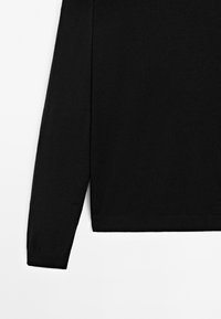 Czarna koszula z długim rękawem i okrągłym dekoltem, wykonana z miękkiego materiału. Posiada prosty dół i dopasowane rękawy. Minimalistyczny design.