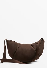 Bruine crossbodytas in halvemaanvorm met verstelbare riem en ritssluiting tegen een effen witte achtergrond.