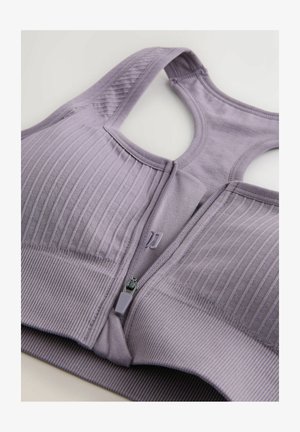 Lichtpaarse sportbeha met geribbelde textuur, ritssluiting aan de voorkant, brede bandjes en gladde stof aan de onderband.