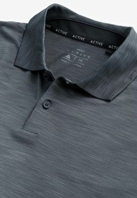 Mørkegrå polo T-shirt lavet af struktureret stof, med en placket med tre knapper, krave og et indvendigt mærke med brandoplysninger.