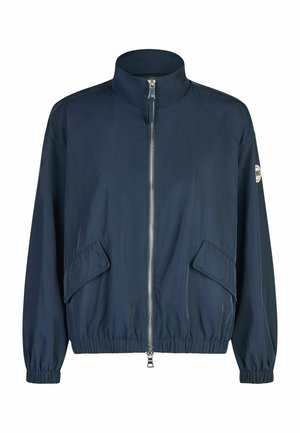 Navy blue zip-up jacket with high collar, elastic cuffs and hem, flap pockets, and logo patch on left sleeve.