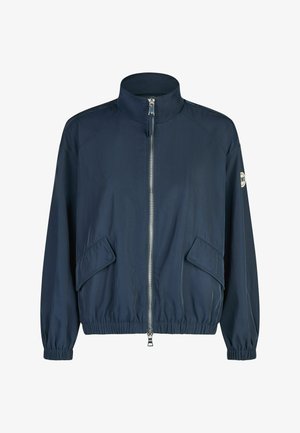 Navy blue zip-up jacket with high collar, elastic cuffs and hem, flap pockets, and logo patch on left sleeve.