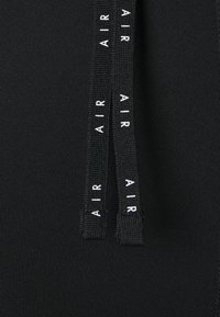 Tissu noir avec deux cordons noirs affichant le mot "AIR" en texte blanc courant verticalement le long de chaque cordon.