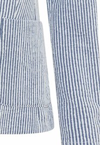 Gestreepte stof in wit en marineblauw, met een gestructureerde afwerking. Het ontwerp bevat een zak en gestructureerde manchetten.