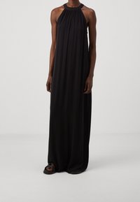 Mustaharaju maksi-dressi, jossa on musta halter-kaula-aukko, valmistettu kevyestä kankaasta. Mekossa on rypistetty yläosa ja virtaava siluetti, sileä tekstuuri ilman kuvioita.