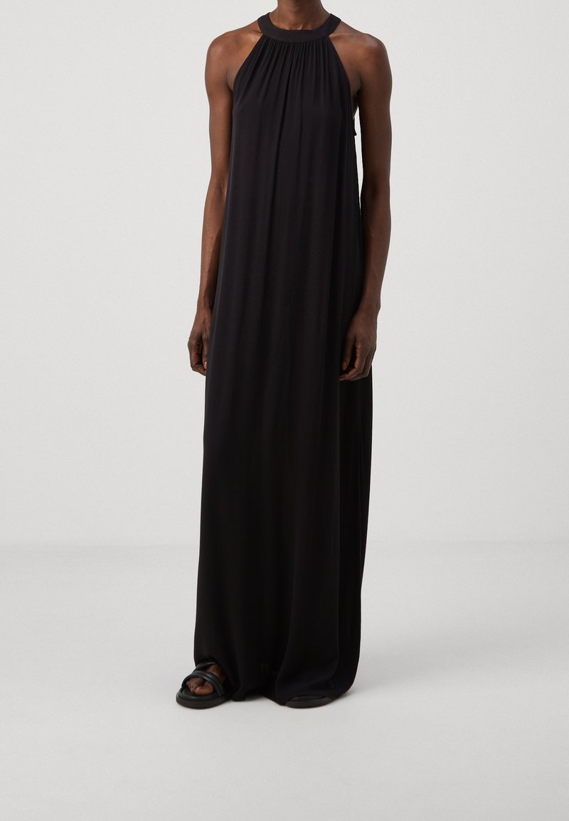 Mustaharaju maksi-dressi, jossa on musta halter-kaula-aukko, valmistettu kevyestä kankaasta. Mekossa on rypistetty yläosa ja virtaava siluetti, sileä tekstuuri ilman kuvioita.