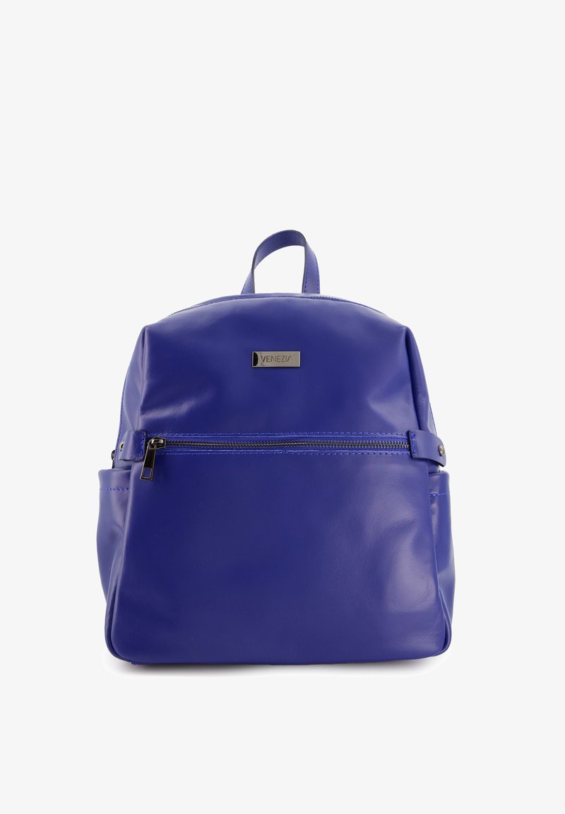 Sac à dos en cuir violet de forme arrondie, avec une poche zippée à l'avant, une poignée supérieure et une branding discrète sur un badge métallique.