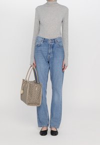 Grå långärmad topp, ljusblå raka jeans, svarta ballerinas och en brun mönstrad axelväska med axelband.