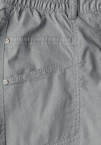 Grå lätta shorts med elastisk midja, utrustade med en enda bakficka och kontrasterande sömmar, tillverkade i ett andningsbart material.
