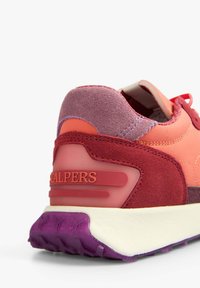 Zapatilla roja y rosa con un upper de ante y sintético, que presenta una suela de goma morada y acentos texturizados en el talón y el logotipo.