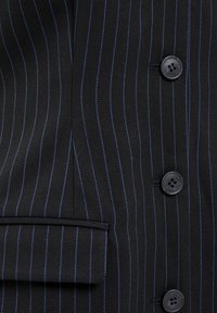 Schwarzer Blazer mit Nadelstreifen in Blau, einem Reverskragen, einer Klapptasche und grauen Knöpfen, gefertigt aus Maßstoff mit glatter Textur.