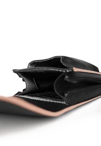 Black leather wallet with multiple compartments, featuring a textured interior, smooth exterior, and tan edging. Zipper and stitching details visible.