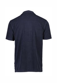 Polo shirt navy a maniche corte realizzato in tessuto morbido, con colletto classico e texture liscia, retro semplice e senza loghi visibili.