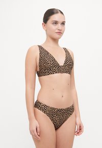 Ensemble de bikini à imprimé léopard comprenant un bralette triangulaire avec des bretelles larges et un bas de bikini taille basse assorti, le tout dans des tons marron et noir.