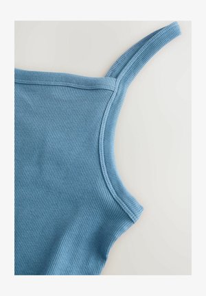 Heledsinine ribaga tank top, millel on õhukesed rihmad ja sile tekstuur, mille lõpetused on kenasti viimistletud. Kaldnurgast vaade, mis rõhutab kaelust.