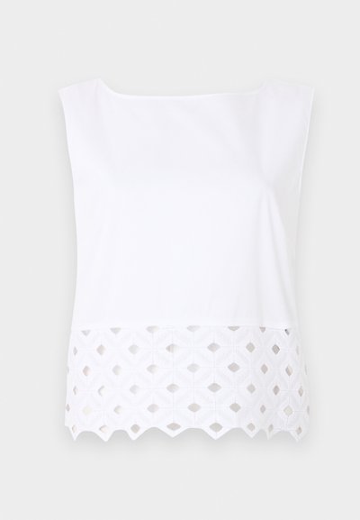 Λευκό αμάνικο τοπ με τετράγωνη λαιμόκοψη και ραμμένη δαντέλα με σχέδιο στο τελείωμα σε ανοιχτό φόντο.