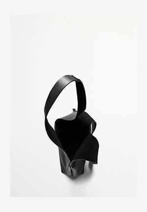 Zwarte leren tas met een brede opening, platte band en gladde textuur. Heeft een minimalistisch ontwerp zonder zichtbare hardware of patronen.