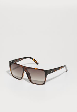 schildpadprint zonnebril met een dik, vierkant frame, gradient lenzen en subtiele metalen accenten op de veren. Gestructureerde afwerking.