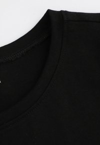 Czarny bawełniany T-shirt z okrągłym dekoltem. Gładka tekstura, minimalne detale szwów, oferujący czysty i prosty design.