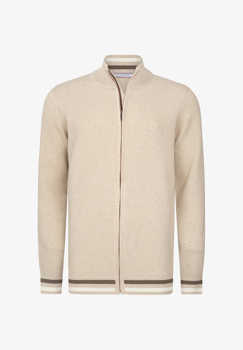 Cardigan color crema con un patrón de punto texturizado, cierre de cremallera y puños acanalados que presentan franjas marrones y blancas. Diseño de cuello alto.