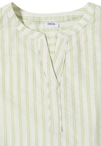 Chemise blanche à rayures verticales vert clair, encolure ronde avec une petite fente avant et une étiquette cousue indiquant "CECIL."