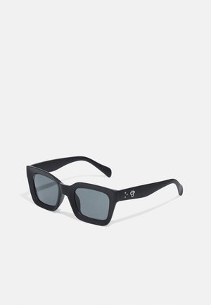 Gafas de sol negras rectangulares con lentes grises, acabado mate y un logo sutil en la patilla. Diseñadas con montura gruesa y templos anchos.