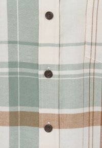 Camicia con bottoni caratterizzata da un motivo a quadri in verde, beige e marrone. Realizzata in tessuto morbido con bottoni marrone scuro e dettagli con tasca.