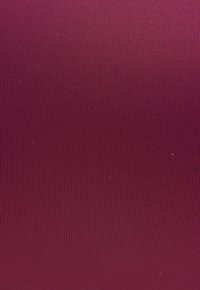 Tessuto bordeaux con una trama a coste, superficie liscia e colore uniforme, adatto per applicazioni in tappezzeria o per abbigliamento.