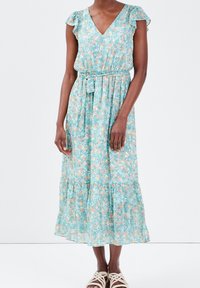 Robe longue fleurie bleu clair avec manches courtes à volants, encolure en V, taille ceinturée et ourlet à volants. Présente un motif floral délicat.