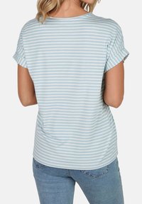 Camiseta de rayas azul claro con mangas enrolladas, hecha de algodón suave. El diseño presenta rayas horizontales de diferentes anchos.