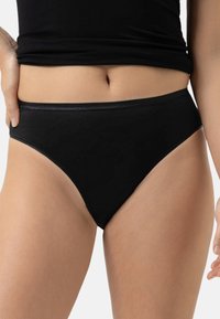 Mutande alte in cotone nero con una texture liscia, caratterizzate da un design semplice e una vita elasticizzata. Senza motivi visibili o accessori.