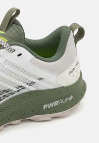 Scarpa da corsa con tomaia in rete bianca, dettagli verdi, collare testurizzato e intersuola verdi macchiettata con il marchio "PWRRUN+".