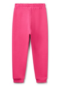 Světlé růžové tepláky s elastickým pasem a ribbovanými manžetami, položené na bílém pozadí.