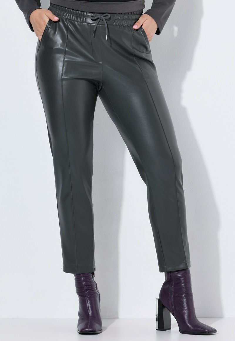 Tmavě šedé kalhoty z umělé kůže s elastickým pasem a šňůrkou. Hladká textura, zúžený střih, boční kapsy, doplněné o fialové kozačky na podpatku.