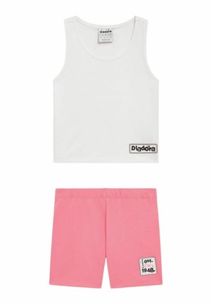 Top bianco senza maniche a taglio corto con patch logo nero abbinato a pantaloncini rosa con vita elastica e una piccola patch grafica sulla gamba.