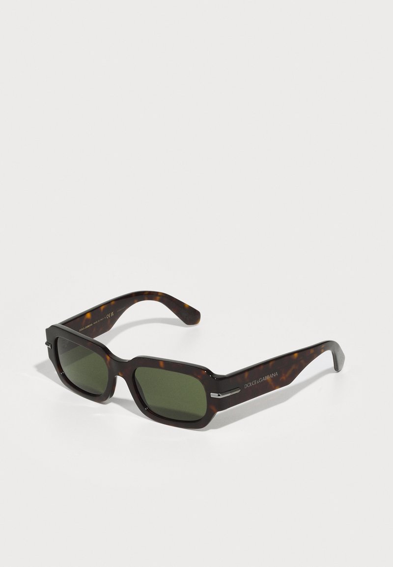 Brown tortoiseshell sunglasses with green lenses, square shape, subtle silver accents on the temples, and a smooth plastic texture.